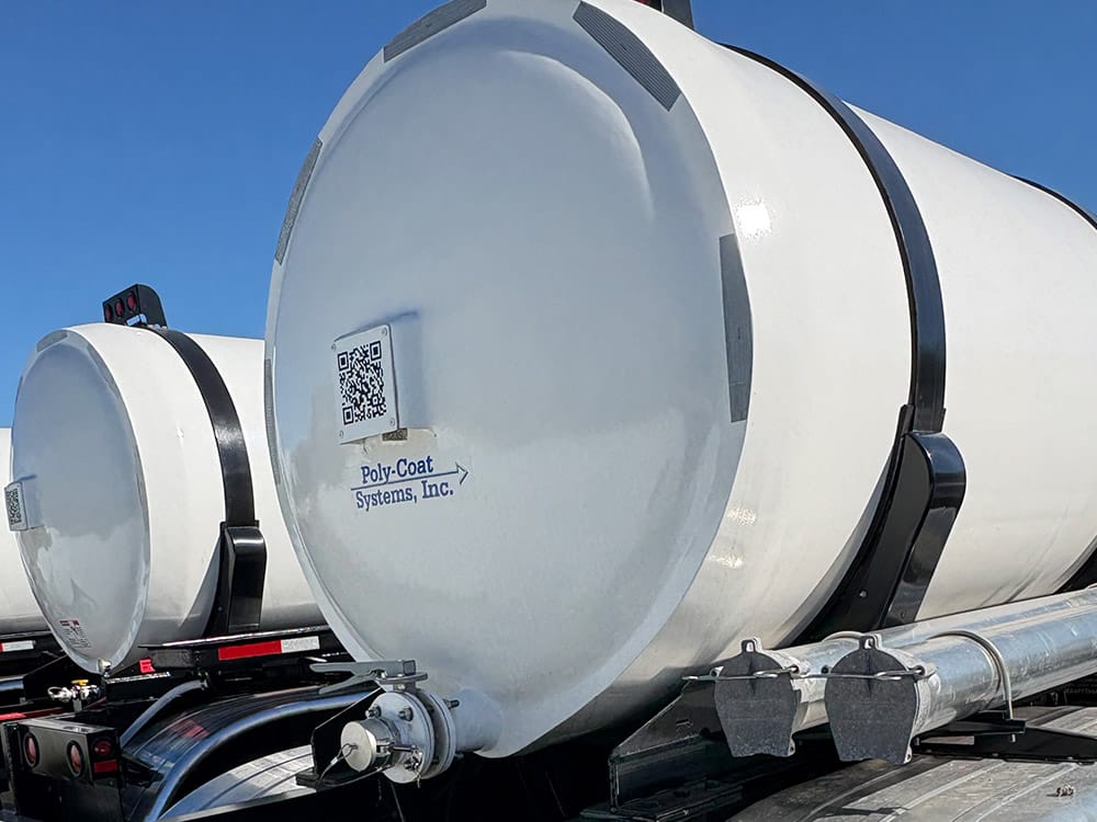 Food-grade tank trailer from Poly-Coat Systems showing the tank head, discharge system and hose carriers.