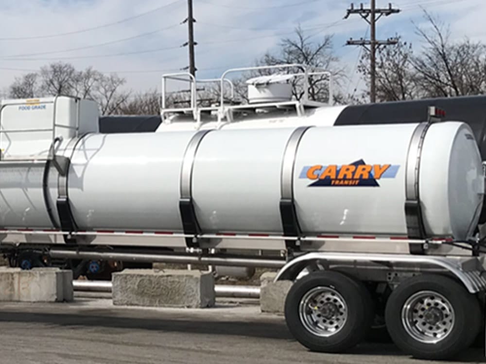 Food-grade tank trailer image for Poly-Coat Systems showing a stainless steel tanker from the side.