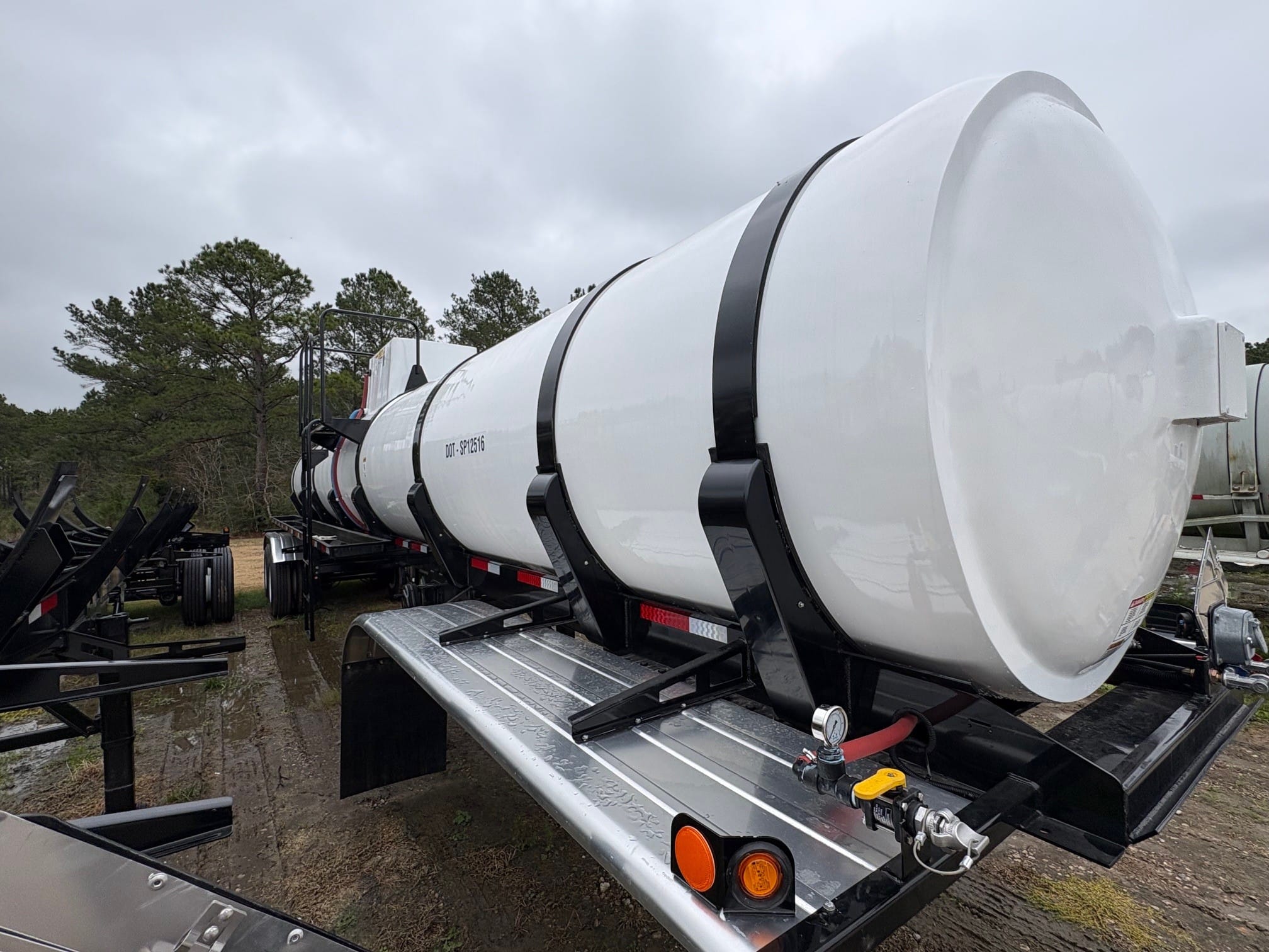 Fiberglass reinforced plastic tank trailer from Poly-Coat Systems showing the tank head, support bands and valve assembly.